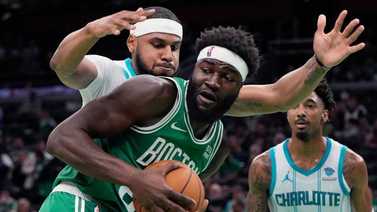 Boston Celtics' Neemias Queta (88) keeps the ball away from Charlotte Hornets' Marques Bolden during the second half of an NBA basketball game, Friday, April 12, 2024, in Boston. (Michael Dwyer/AP Photo)