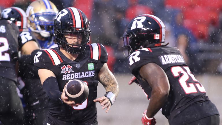 Ottawa Redblacks quarterback Dru Brown (3) hands the ball to Ottawa Redblacks' Ryquell Armstead (25) during first half CFL action against the Winnipeg Blue Bombers in Ottawa on Thursday, June 13, 2024. (Patrick Doyle/CP)