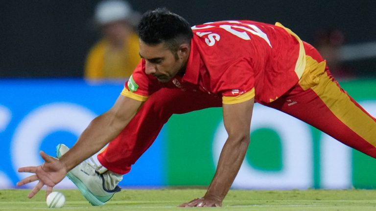 Canada's Saad Bin Zafar reaches down to field the ball during a T20 World Cup cricket match. (AP Photo/Julio Cortez)