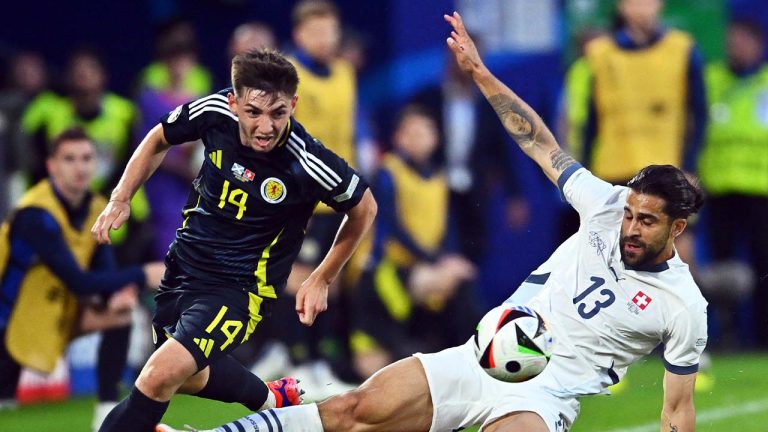 Scotland's Billy Gilmour (14) and Switzerland's Ricardo Rodriguez (13) battle for the ball during a Group A match between Scotland and Switzerland at the Euro 2024 soccer tournament in Cologne, Germany, Wednesday, June 19, 2024. (Marius Becker/AP)