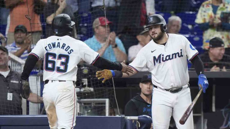 Miami Marlins' Jake Burger, right, congratulates Xavier Edwards (63) after Edwards and Nick Gordon scored on a double by Jazz Chisholm Jr., during the seventh inning of a baseball game against the Baltimore Orioles, Wednesday, July 24, 2024, in Miami. (Wilfredo Lee/AP)
