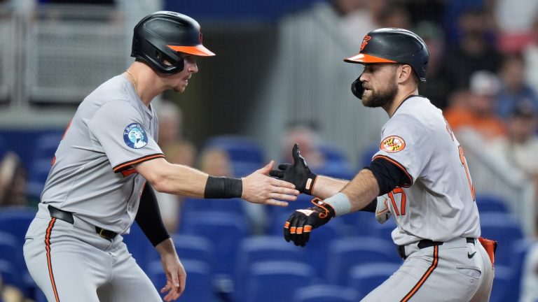 Baltimore Orioles designated hitter Ryan O'Hearn, left, congratulates Colton Cowser after Cowser hit a home run scoring O'Hearn and Ryan Mountcastle, during the third inning of a baseball game against the Miami Marlins, Thursday, July 25, 2024, in Miami. (AP Photo/Wilfredo Lee)