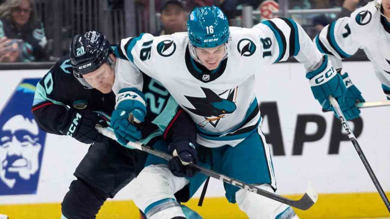 San Jose Sharks centre Jack Studnicka (16) battles for the puck with Seattle Kraken right wing Eeli Tolvanen (20) during the second period of an NHL hockey game, Thursday, April 11, 2024, in Seattle. (John Froschauer/AP)