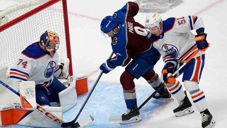 Colorado Avalanche left wing Zach Parise, centre, puts a shot on Edmonton Oilers goaltender Stuart Skinner, left, after driving past defenseman Troy Stecher during the first period of an NHL hockey game Thursday, April 18, 2024, in Denver. (David Zalubowski/AP)