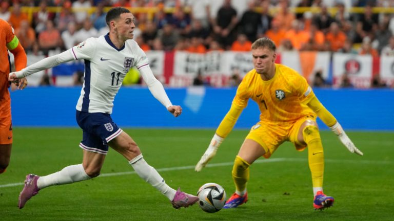 England's Phil Foden, left, and Netherlands goalkeeper Bart Verbruggen battle for the ball during a semifinal at the Euro 2024 soccer tournament in Dortmund, Germany, Wednesday, July 10, 2024. (AP Photo/Thanassis Stavrakis) 