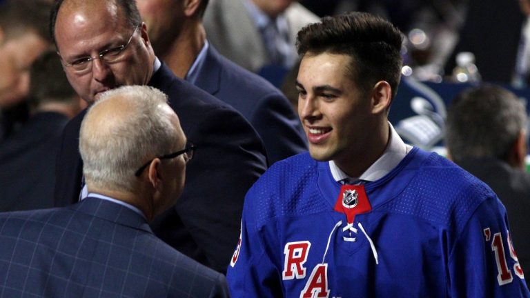 New York Rangers select Matthew Robertson, centre, shakes hands with an official during the second round of the NHL draft at Rogers Arena in Vancouver, June 22, 2019. (THE CANADIAN PRESS/Chad Hipolito)