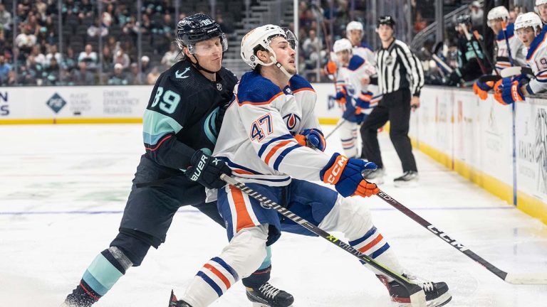 Edmonton Oilers forward Noah Philp, right, and Seattle Kraken forward Ville Petman battle for the puck during the second period of a preseason NHL hockey game, Monday, Sept. 26, 2022, in Seattle. The Kraken won 3-0. (Stephen Brashear/AP)