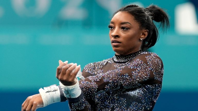 Simone Biles, of United States, waits to compete on the uneven bars during a women's artistic gymnastics qualification round at Bercy Arena at the 2024 Summer Olympics, July 28, 2024. (AP Photo/Charlie Riedel)