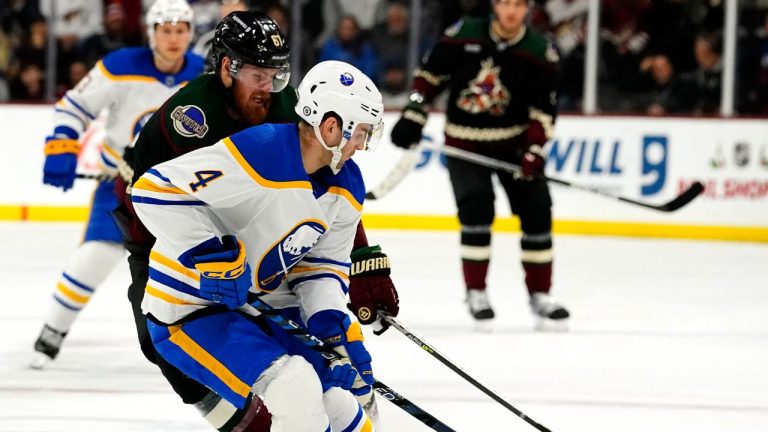 Buffalo Sabres' Jeremy Davis (4) and Arizona Coyotes' Lawson Crouse (67) battle for the puck in the first period during an NHL hockey game, Saturday, Dec. 17, 2022, in Tempe, Ariz. (Darryl Webb/AP Photo)