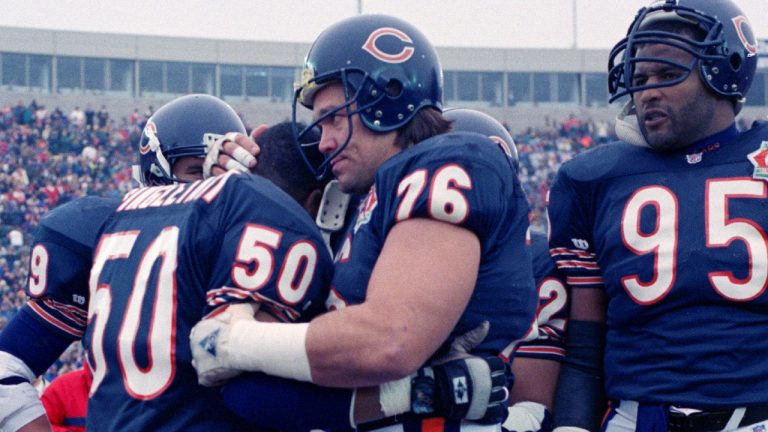 Chicago Bears' Mike Singletary (50) gets a bear hug from teammate Steve McMichael (76) prior to an NFL game against the Pittsburgh Steelers, Dec. 13, 1992. (AP Photo/David Boe, File)