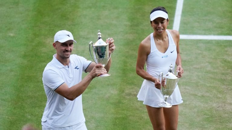 Taiwan's Su-Wei Hsieh and Poland's Jan Zielinski hold their trophy's as they walk around Center Court after defeating Mexico's Santiago Gonzalez and compatriot Giuliana Olmos in the mixed doubles final at Wimbledon, July 14, 2024. (AP Photo/Mosa'ab Elshamy)