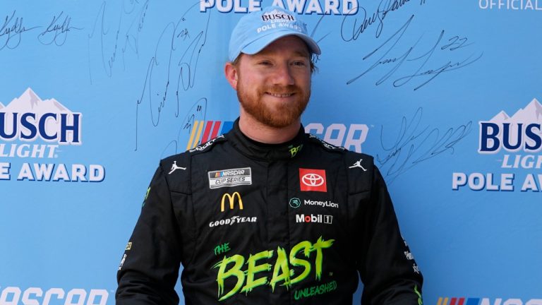Tyler Reddick stands while holding the pole award for the NASCAR Cup Series at Indianapolis Motor Speedway, July 20, 2024. (AP Photo/Darron Cummings)