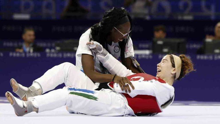 Zakia Khudadadi from the Paralympic Refugee Team, bottom, celebrates her bronze medal in Para Taekwondo during the Paralympic Games in Paris, Thursday, Aug. 29, 2024. (Madeleine Mertens/AP)