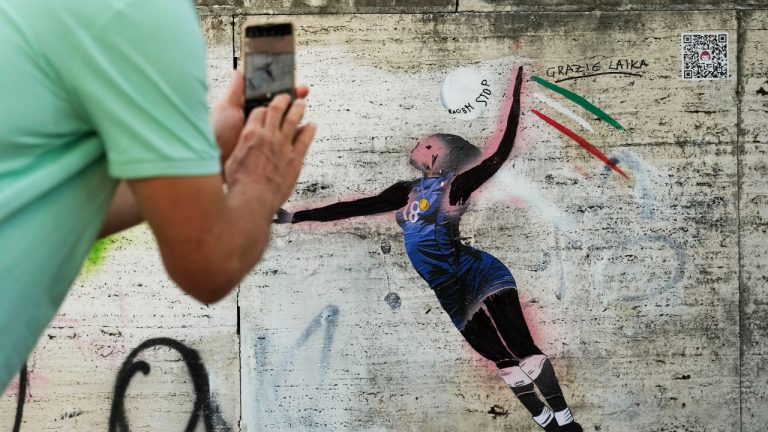 A man takes a picture at Laika's street-art celebration of Paola Egonu, who helped lead Italy to its first-ever Olympic gold medal in women's volleyball, in Rome, Wednesday, Aug. 14, 2024. (Gregorio Borgia/AP)