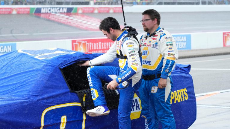 Chase Elliott exits his car during a rain delay of a NASCAR Cup Series auto race at Michigan International Speedway, Sunday, Aug. 18, 2024, in Brooklyn, Mich. (Carlos Osorio/AP)