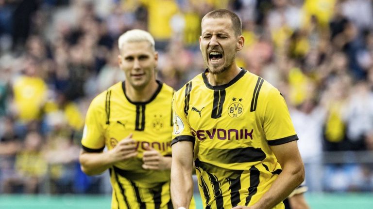 Dortmund's Waldemar Anton, right, celebrates scoring his side's opening goal during the German Cup soccer match between Dortmund and Phoenix Lubeck in Hamburg, Germany, Saturday, Aug. 17, 2024. (Axel Heimken/dpa via AP)
