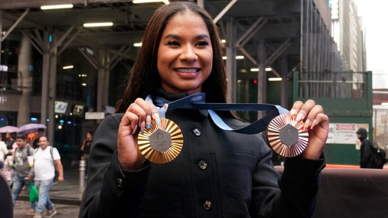 Two-time U.S. Olympic gymnast medalist Jordan Chiles shows her medals after ringing the closing bell at the Nasdaq MarketSite, in New York's Times Square, Thursday, Aug. 8, 2024. (Richard Drew/AP)