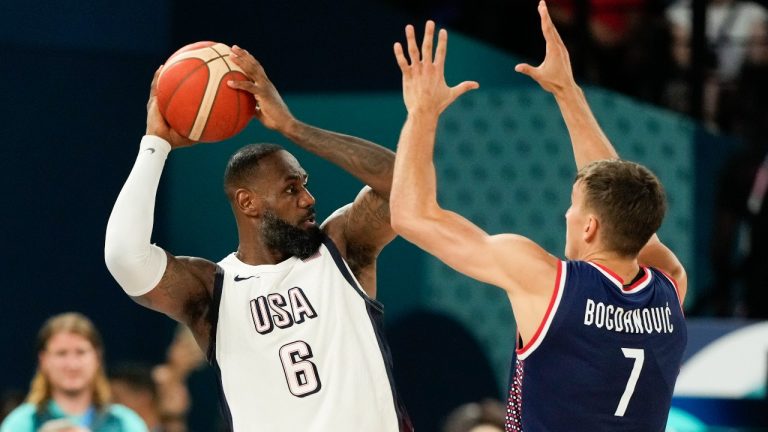  United States' LeBron James (6) passes over Bogdan Bogdanovic (7), of Serbia during a men's semifinals basketball game at Bercy Arena at the 2024 Summer Olympics, Thursday, Aug. 8, 2024, in Paris, France. (Mark J. Terrill/AP)