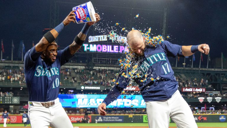 Seattle Mariners' Victor Robles, left, douses Mitch Haniger with a bucket of bubble gum and ice water after Hanger's three-RBI, walk-off double during the ninth inning of a baseball game against the Detroit Tigers, Thursday, Aug. 8, 2024, in Seattle. The Mariners won 4-3. (Jason Redmond/AP)