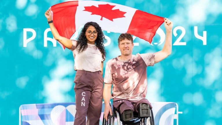 Katarina Roxon and Patrick Anderson pose for photos as Canada’s flag-bearers for the opening ceremony of the 2024 Paralympic Games in Paris, France on August 25, 2024. (Dave Holland/CANADIAN PARALYMPIC COMMITTEE)