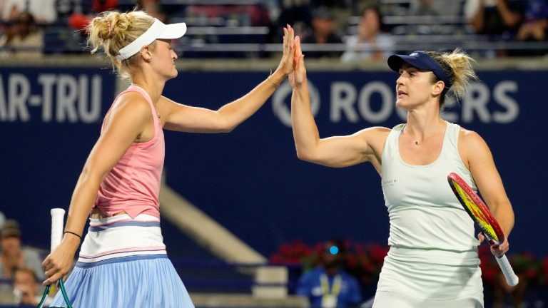 Gabriela Dabrowski, right, of Ottawa, high fives teammate Erin Routliffe, of New Zealand, during women's doubles final action at the National Bank Open, in Toronto, Aug. 12, 2024. Canada's Gabriela Dabrowski and New Zealand's Erin Routliffe opened their U.S. Open women's doubles title defence Thursday with a 6-4, 6-2 win over Canada's Leylah Fernandez and Yulia Putintseva of Kazakhstan. (Frank Gunn/CP)