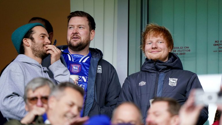 Ipswich Town fan Ed Sheeran, right, looks on in the stands prior to the start of the English Championship soccer match Between Ipswich Town and Norwich City at Portman Road, in Ipswich, England, Saturday, Dec. 16, 2023. (Joe Giddens/PA via AP)