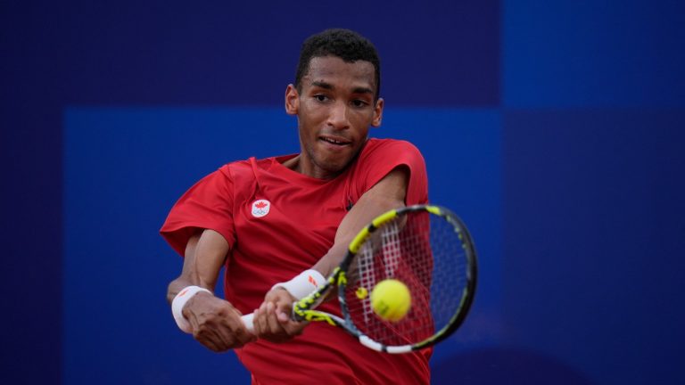 Felix Auger-Aliassime of Canada returns a backhand shot to Casper Ruud of Norway during their men's singles quarterfinals tennis match, at the 2024 Summer Olympics, Thursday, Aug.1, 2024, at the Roland Garros stadium in Paris, France. (Andy Wong/AP Photo)