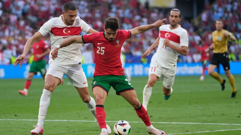 Portugal's Pedro Neto, centre, challenges for the ball with Turkey's Merih Demiral, left, during a Group F match between Turkey and Portugal at the Euro 2024 soccer tournament in Dortmund, Germany, Saturday, June 22, 2024. (Darko Vojinovic/AP)