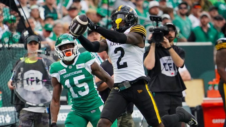 Hamilton Tiger-Cats defensive back Jamal Peters (2) intercepts the football as Saskatchewan Roughriders receiver Shawn Bane Jr. (15) looks on during the first half of CFL football action in Regina, on Sunday, June 23, 2024. (CP/Heywood Yu)