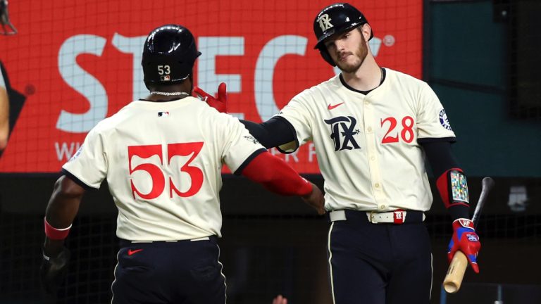 Texas Rangers' Adolis Garcia (53) celebrates with Jonah Heim (28) after scoring on a single by Nathaniel Lowe in the fourth inning of a baseball game against the Seattle Mariners, Friday, Sept. 20, 2024, in Arlington, Texas. (Richard W. Rodriguez/AP)