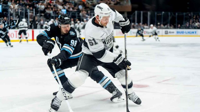 Los Angeles Kings centre Trevor Lewis (61) moves the puck ahead of Utah Hockey Club defenceman Mikhail Sergachev (98) during the first period of a pre-season NHL hockey game. (Spenser Heaps/AP)