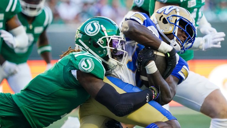 Saskatchewan Roughriders linebacker C.J. Reavis (1) tackles Winnipeg Blue Bombers receiver Lucky Whitehead (13) during the first half of CFL football action in Regina, on Sunday, September 1, 2024. (Heywood Yu/CP)