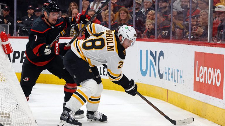 Boston Bruins' Elias Lindholm (28) controls the puck in front of Carolina Hurricanes Dmitry Orlov (7) during the first period of an NHL hockey game in Raleigh, N.C., Thursday, Oct. 31, 2024. (Karl B DeBlaker/AP)