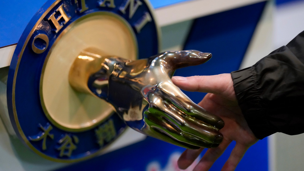 A visitor shakes hands with an iron model of Shohei Ohtani of the Los Angeles Dodgers, displayed at a local municipal government building in Oshu, northeastern Japan, the hometown of Ohtani, Tuesday, Oct. 29, 2024. (Eugene Hoshiko/AP)