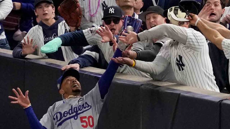 Fans interfere with a foul ball caught by Los Angeles Dodgers right fielder Mookie Betts during the first inning in Game 4 of the baseball World Series against the New York Yankees, Tuesday, Oct. 29, 2024, in New York. (Ashley Landis/AP)