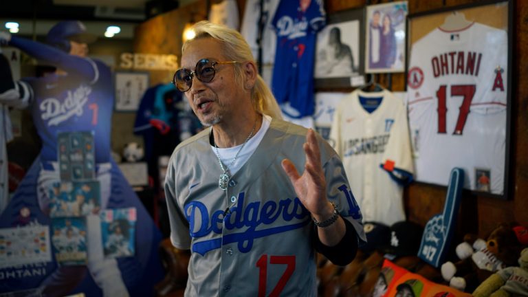 Hironobu Kanno, representative of a private fan club of Shohei Ohtani of the Los Angeles Dodgers, speaks surrounded by his collection goods of Ohtani at his beauty salon in Oshu, northeastern Japan, the hometown of Ohtani, Tuesday, Oct. 29, 2024. (Eugene Hoshiko/AP)