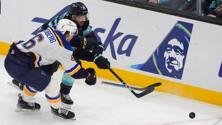 St. Louis Blues defenseman Philip Broberg (6) and Seattle Kraken right wing Oliver Bjorkstrand (22) vie for the puck during the first period of an NHL hockey game Tuesday, Oct. 8, 2024, in Seattle. (Lindsey Wasson/AP)