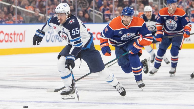 Winnipeg Jets' Mark Scheifele (55) carries the puck ahead of Edmonton Oilers' Evan Bouchard (2) during first period NHL action in Edmonton on Wednesday, October 9, 2024. (Amber Bracken/CP)