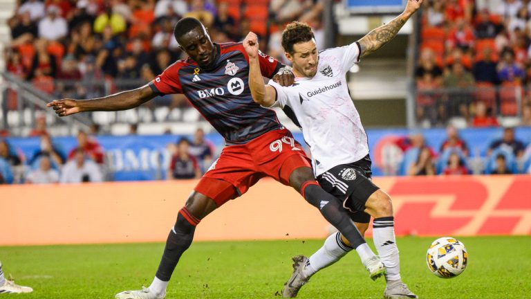 Toronto FC forward Prince Osei Owusu (99) and D.C. United defender Aaron Herrera (22) vie for possession of the ball during MLS soccer action in Toronto on Saturday, August 31, 2024. (Christopher Katsarov/CP)