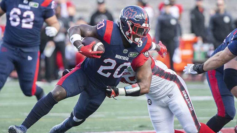 Montreal Alouettes' Jeshrun Antwi (20) is tackled by Ottawa Redblacks' Avery Williams during first half CFL football action in Montreal, Monday, October 10, 2022. The B.C. Lions acquired Canadian running back Jeshrun Antwi from the Montreal Alouettes on Wednesday. (Graham Hughes/CP)