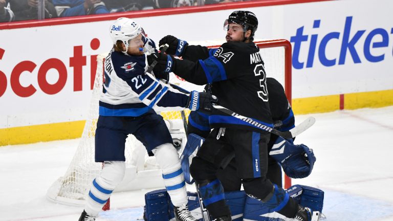 Toronto Maple Leafs' Auston Matthews (34) and Winnipeg Jets' Mason Appleton (22) battle for position in front of the the net during first period NHL hockey action in Winnipeg on Monday, October 28, 2024. (Fred Greenslade/CP)