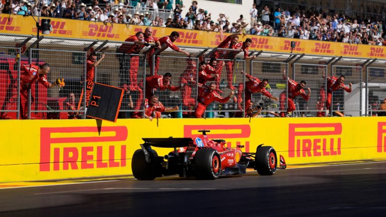 Team members stand along the fence celebrating as Ferrari driver Charles Leclerc, of Monaco, wins the U.S. Grand Prix auto race at Circuit of the Americas, Sunday, Oct. 20, 2024, in Austin, Texas. (Eric Gay/AP)