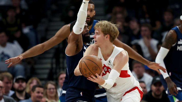 Toronto Raptors guard Gradey Dick, right, passes with pressure from Minnesota Timberwolves guard Mike Conley, left, during the second half of an NBA basketball game. (Ellen Schmidt/AP)