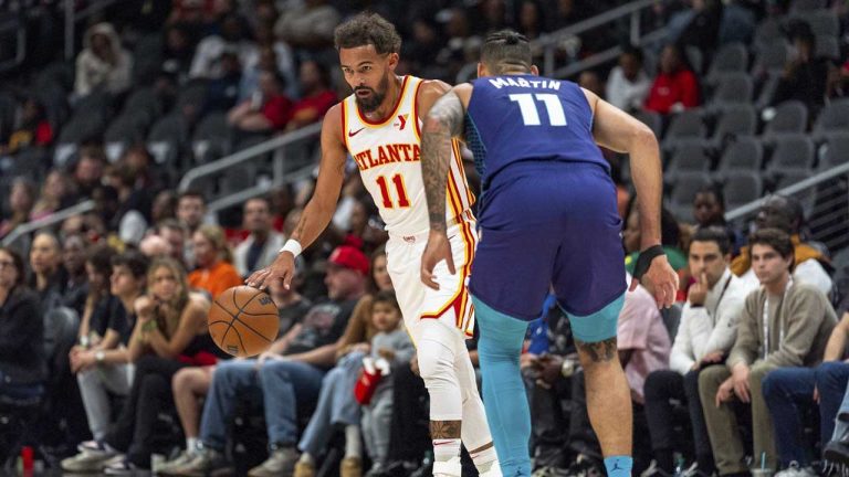 Atlanta Hawks guard Trae Young, left, dribbles while guarded by Charlotte Hornets forward Cody Martin, right, during the first half of an NBA basketball game. (Jason Allen/AP)