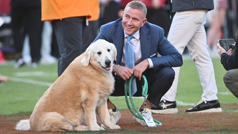 ESPN's Kirk Herbstreit and his dog Ben watch players warm up before the start of an NCAA college football game between Tennessee and Arkansas, Saturday, Oct. 5, 2024, in Fayetteville, Ark. (Michael Woods/AP)