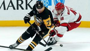 Pittsburgh Penguins' Evgeni Malkin (71) reaches for the puck against Carolina Hurricanes' Jordan Martinook (48) during the first period of an NHL hockey game, Friday, Oct. 18, 2024, in Pittsburgh. (Matt Freed/AP)