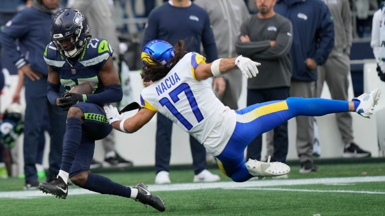 Seattle Seahawks cornerback Riq Woolen, left, intercepts a pass intended for Los Angeles Rams wide receiver Puka Nacua (17). (Stephen Brashear/AP)