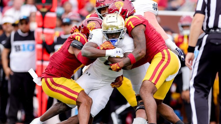 Notre Dame running back Jeremiyah Love, center, is tackled by Southern California safetys Akili Arnold, left, and Kamari Ramsey during the first half of an NCAA football game, Saturday, Nov. 30, 2024, in Los Angeles. (Ryan Sun/AP Photo)