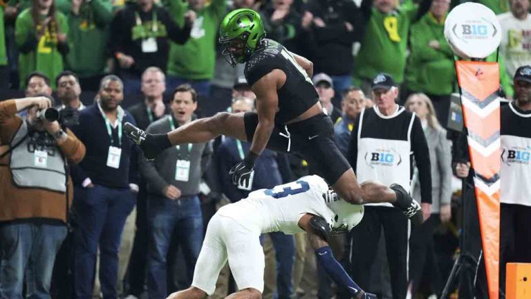Oregon tight end Kenyon Sadiq (18) leaps over Penn State cornerback Jalen Kimber (3) during a 28-yard touchdown reception in the first half of the Big Ten championship NCAA college football game, Saturday, Dec. 7, 2024, in Indianapolis. (AJ Mast/AP)