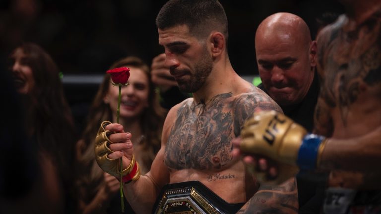 UFC featherweight champion Ilia Topuria, holds a rose presented to him by his wife after winning a featherweight title mixed martial arts bout against Max Holloway at UFC 308 in Abu Dhabi, United Arab Emirates. (Altaf Qadri/AP)
